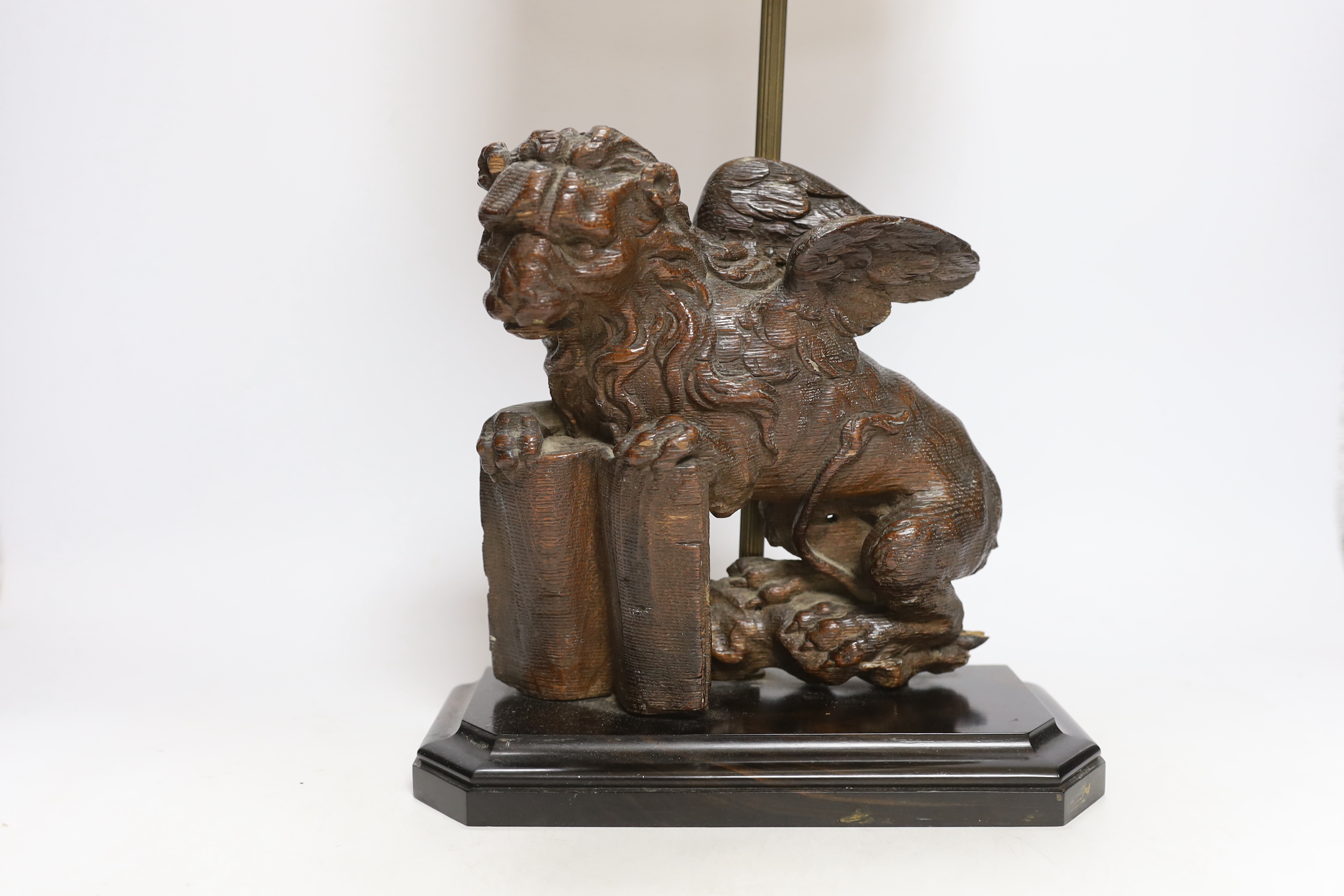 An 18th century oak carving of a Heraldic lion, now as a lamp, 55cm high including shade